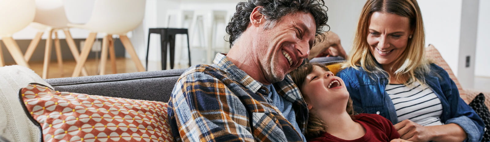 Family laughing and sitting on a couch