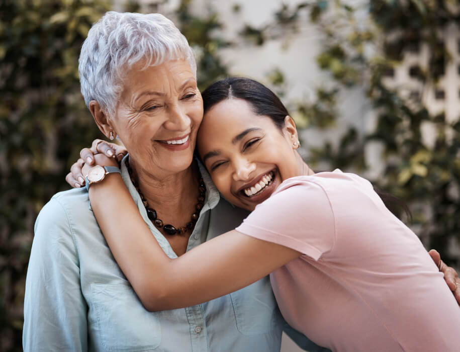 Mature woman and young woman happily hugging