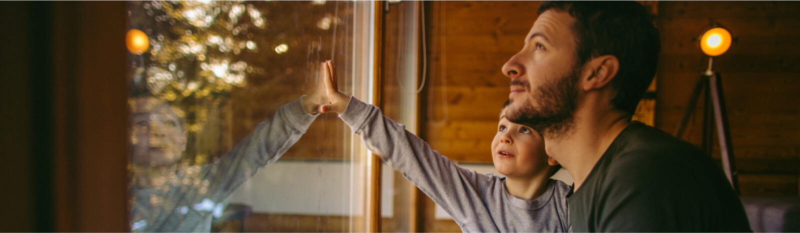 Man and young kid looking out a large window