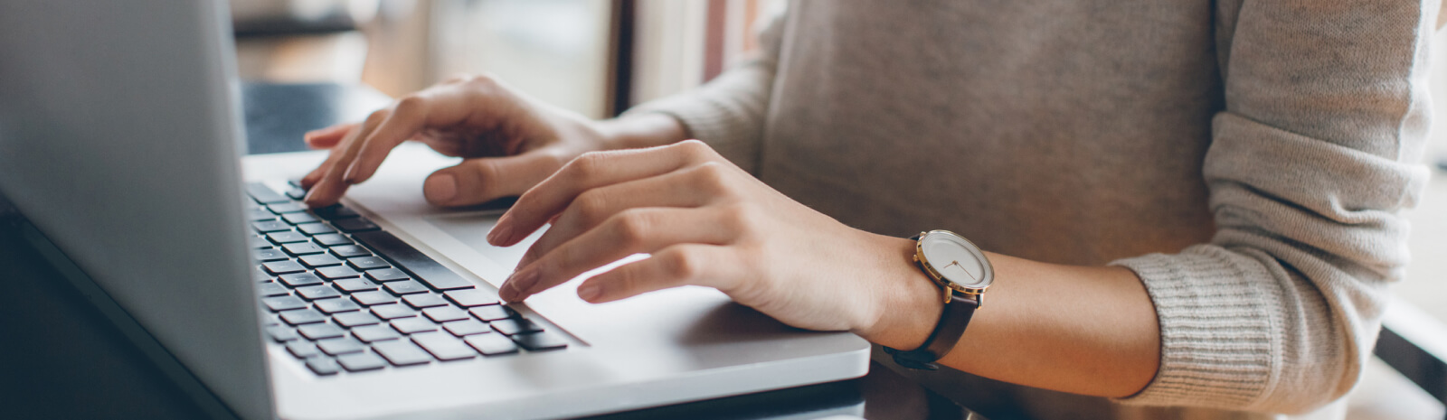 Close up of hands typing on a laptop keyboard