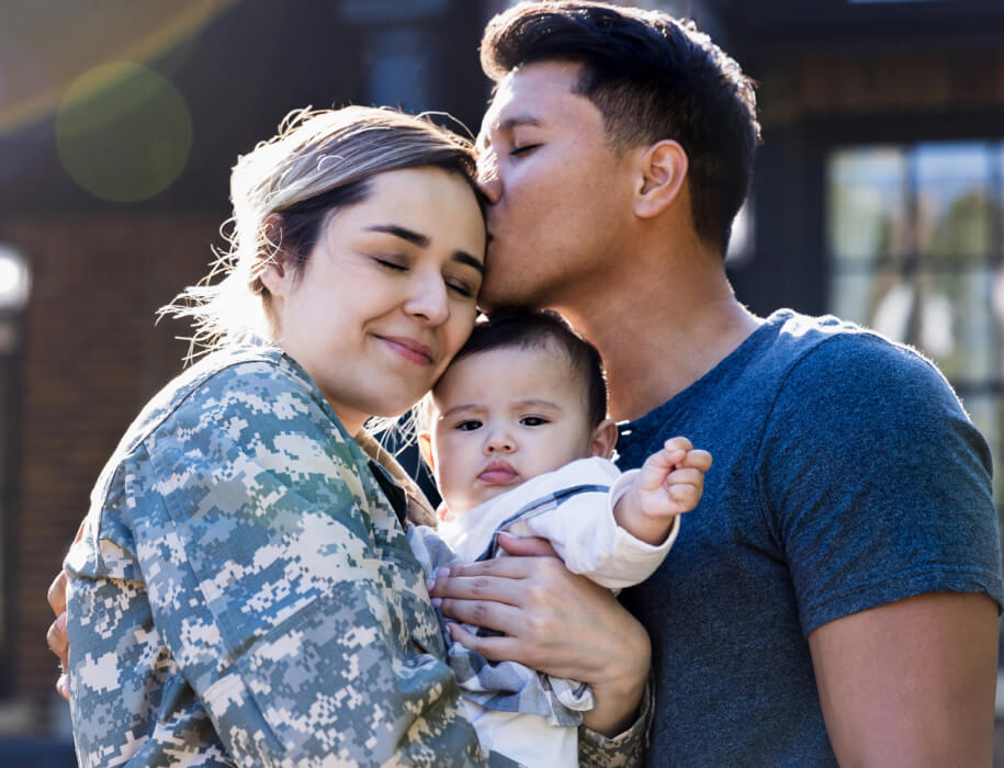 Woman in military clothing with husband and baby