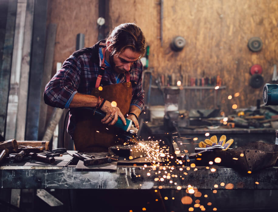 A man in a workshop manipulating steel